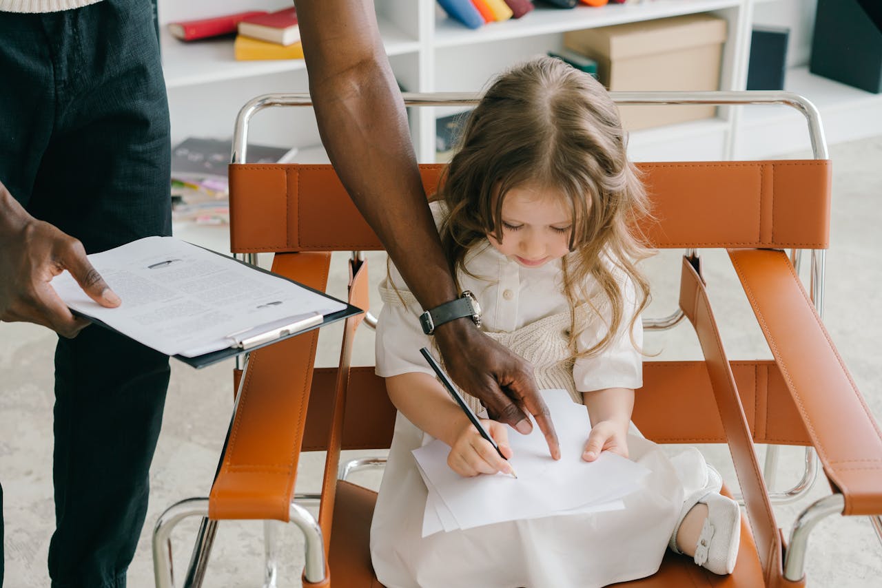 Person Teaching the Girl How to Write